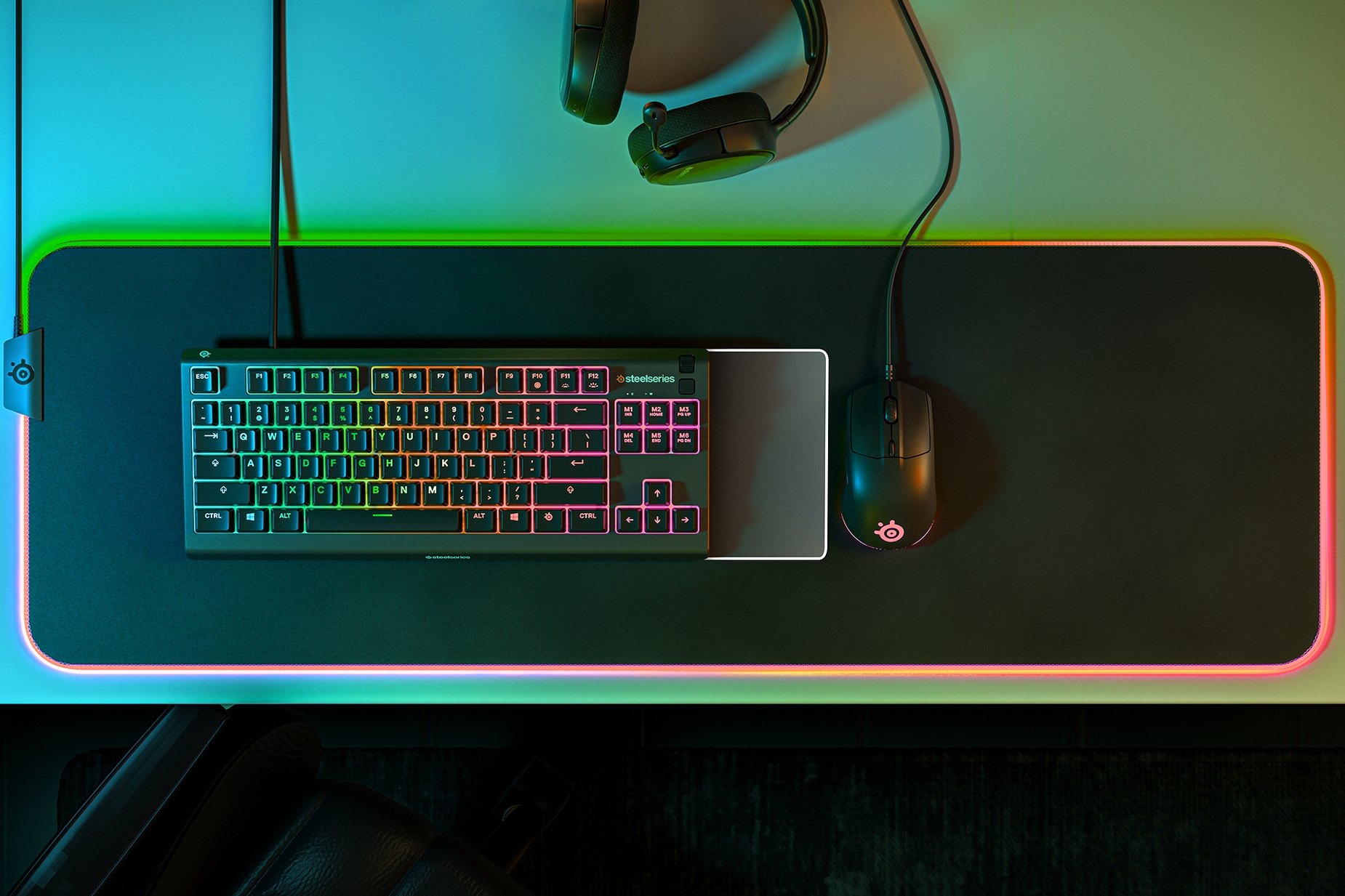 
 Overhead view of an Apex 3 Tkl keyboard, SteelSeries mouse, Prism mousepad and headset, all glowing with RGB.
 