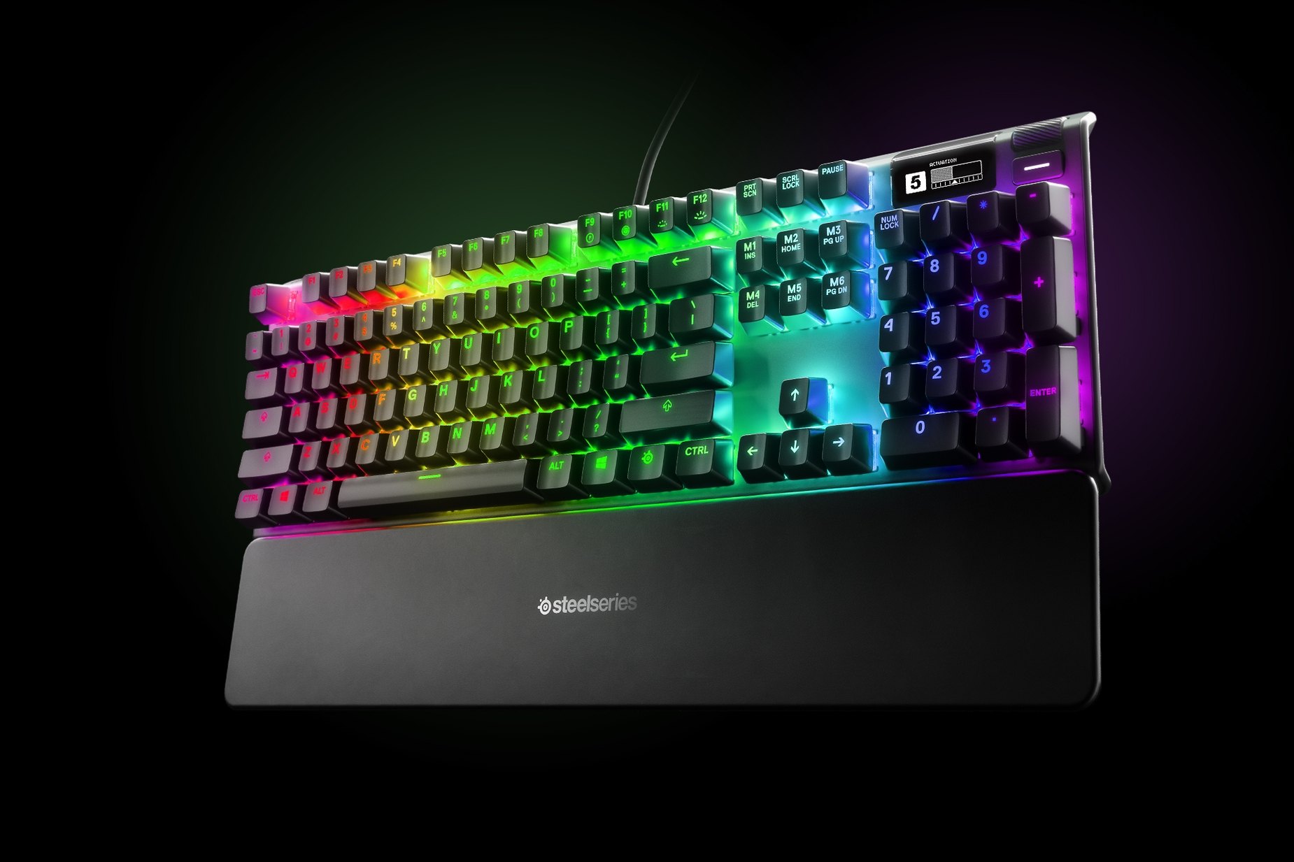 
 Thai - Apex Pro gaming keyboard with the illumination lit up on dark background, also shows the OLED screen and controls used to change settings, switch actuation, and adjust audio
 